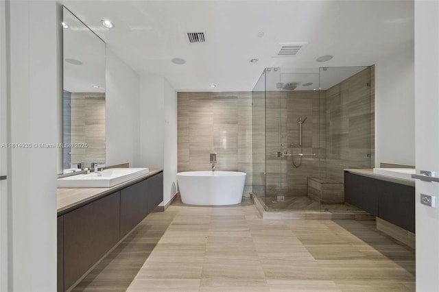 3250 NE 188th St Unit Lph07, Aventura, FL 33180 - bathroom with vanity, a shower stall, a freestanding bath, and tile walls