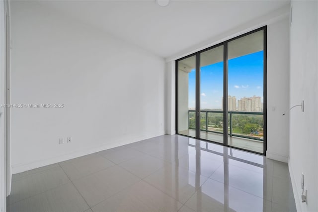 3250 NE 188th St Unit Lph07, Aventura, FL 33180 - tiled spare room featuring expansive windows, baseboards, and a view of city