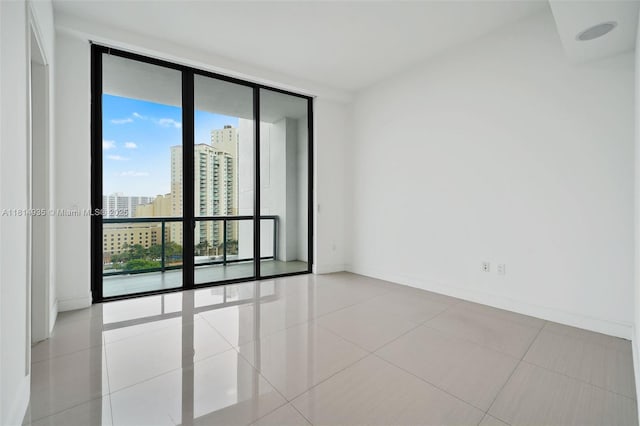3250 NE 188th St Unit Lph07, Aventura, FL 33180 - unfurnished room with floor to ceiling windows, baseboards, a city view, and tile patterned flooring