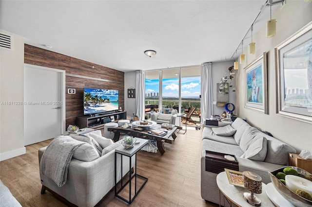 15051 Royal Oaks Ln Unit 2101, North Miami, FL 33181 - living area featuring wood walls, expansive windows, wood finished floors, and an accent wall