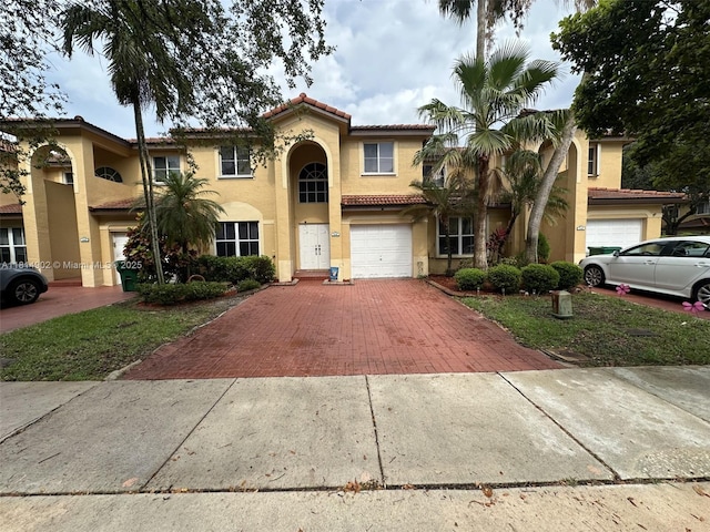 238 Magnolia Ave, Davie, FL 33325 - mediterranean / spanish-style home featuring decorative driveway, a tile roof, an attached garage, and stucco siding