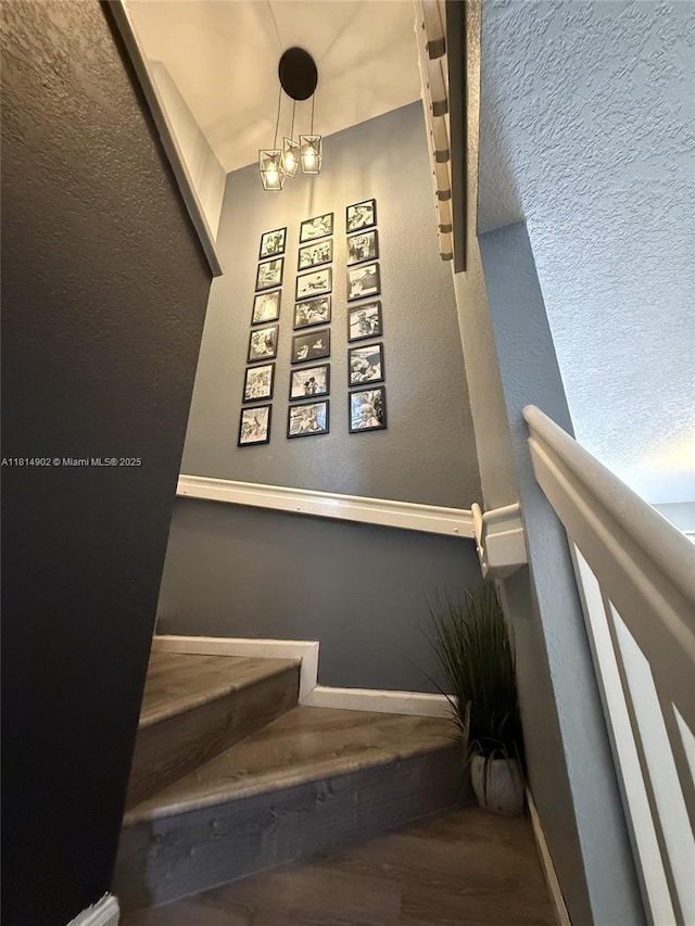 238 Magnolia Ave, Davie, FL 33325 - stairs with a textured wall, wood finished floors, a chandelier, and baseboards