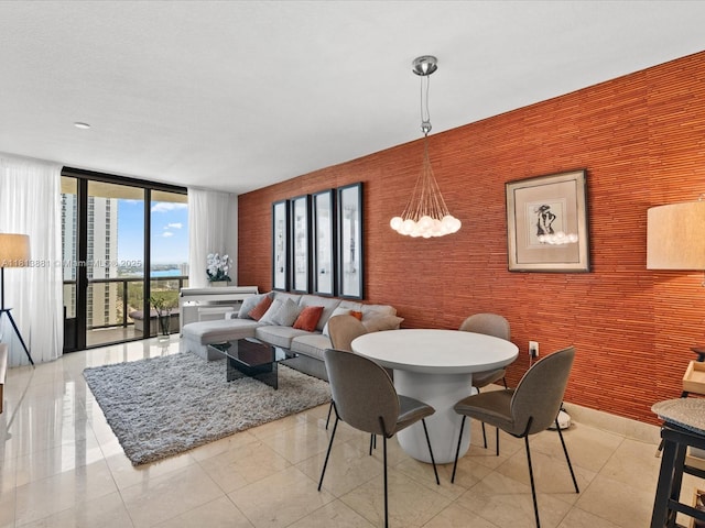 16275 Collins Ave Unit 2103, Sunny Isles Beach, FL 33160 - dining room with a wall of windows, an accent wall, wallpapered walls, and a chandelier