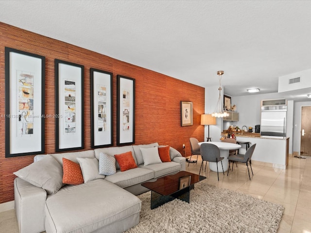 16275 Collins Ave Unit 2103, Sunny Isles Beach, FL 33160 - living area with a chandelier, light tile patterned flooring, baseboards, and an accent wall
