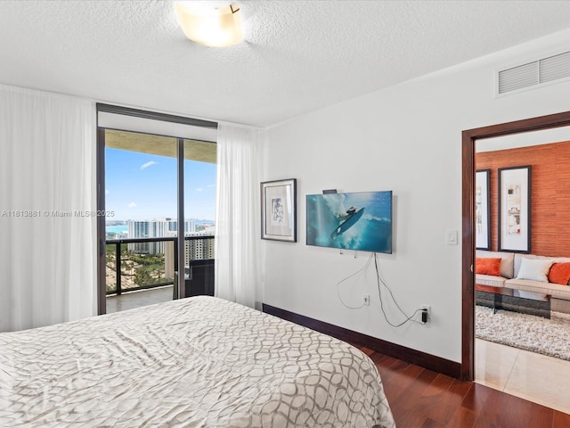 16275 Collins Ave Unit 2103, Sunny Isles Beach, FL 33160 - bedroom with access to outside, dark wood-style flooring, expansive windows, baseboards, and a textured ceiling