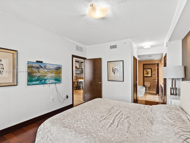 16275 Collins Ave Unit 2103, Sunny Isles Beach, FL 33160 - bedroom featuring dark wood finished floors, a textured ceiling, ensuite bathroom, and baseboards