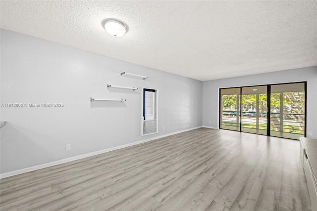 2302 S Cypress Bend Dr Unit 210, Pompano Beach, FL 33069 - unfurnished room featuring a textured ceiling, wood finished floors, and baseboards