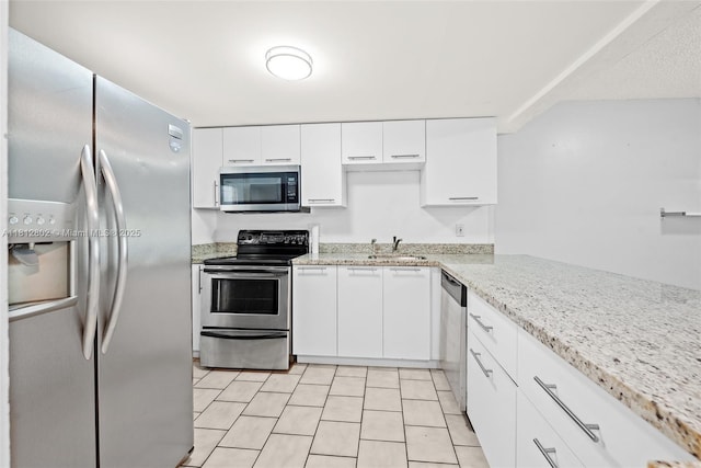2302 S Cypress Bend Dr Unit 210, Pompano Beach, FL 33069 - kitchen featuring appliances with stainless steel finishes, a sink, white cabinetry, and light tile patterned floors