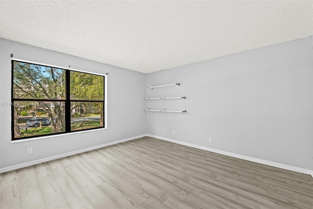 2302 S Cypress Bend Dr Unit 210, Pompano Beach, FL 33069 - empty room featuring wood finished floors, a textured ceiling, and baseboards
