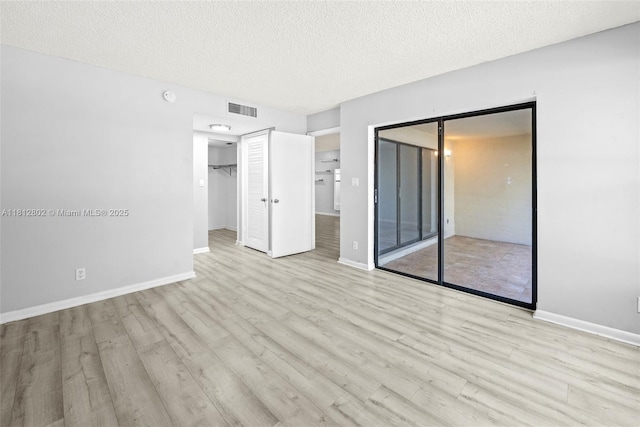 2302 S Cypress Bend Dr Unit 210, Pompano Beach, FL 33069 - unfurnished bedroom with wood finished floors, baseboards, and a textured ceiling