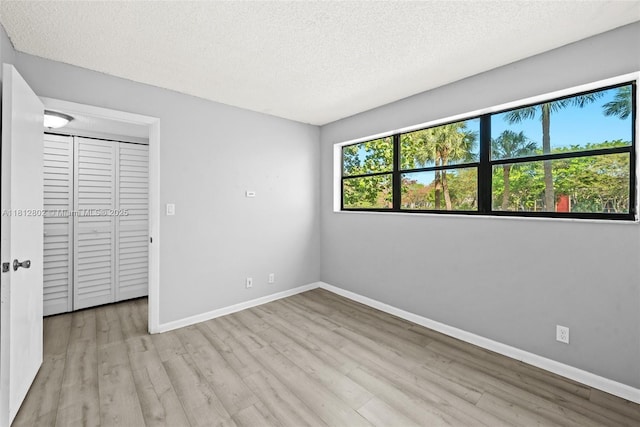 2302 S Cypress Bend Dr Unit 210, Pompano Beach, FL 33069 - unfurnished bedroom featuring wood finished floors, baseboards, and a textured ceiling