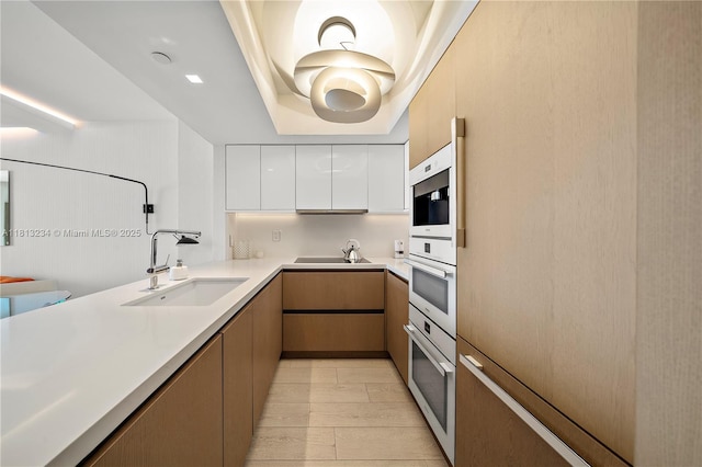 1500 Ocean Dr Unit 910, Miami Beach, FL 33139 - kitchen featuring a sink, modern cabinets, a tray ceiling, white cabinetry, and light countertops