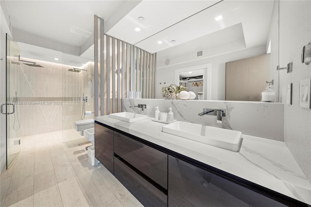 1500 Ocean Dr Unit 910, Miami Beach, FL 33139 - bathroom featuring a stall shower, double vanity, toilet, and wood finished floors