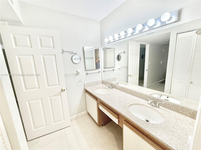 1470 Sheridan St Unit 18C, Hollywood, FL 33020 - full bathroom featuring double vanity, tile patterned flooring, a closet, a textured ceiling, and baseboards