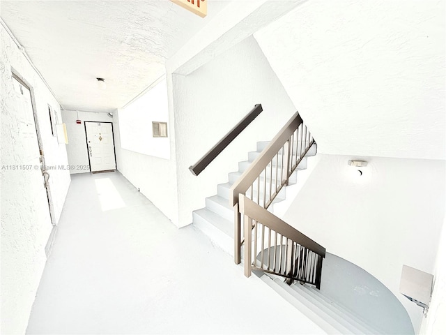 1470 Sheridan St Unit 18C, Hollywood, FL 33020 - hall with a textured ceiling, finished concrete floors, and stairs