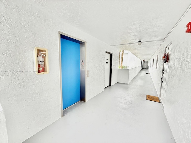 1470 Sheridan St Unit 18C, Hollywood, FL 33020 - hallway featuring a textured wall, elevator, and finished concrete flooring