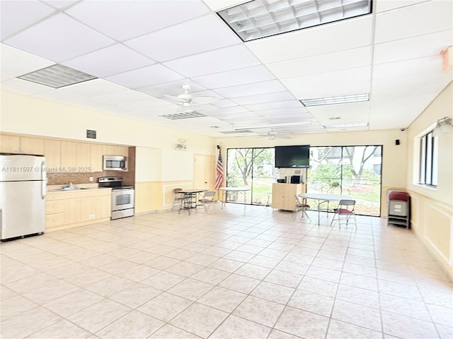 1470 Sheridan St Unit 18C, Hollywood, FL 33020 - kitchen featuring appliances with stainless steel finishes, a ceiling fan, a sink, light brown cabinetry, and a drop ceiling