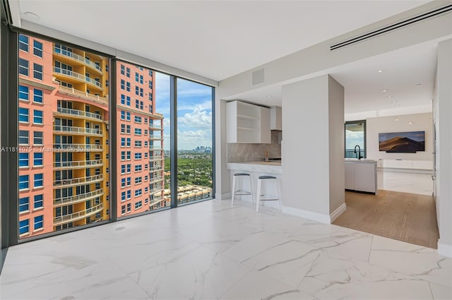 2200 N Ocean Blvd Unit S1801, Fort Lauderdale, FL 33305 - unfurnished living room featuring healthy amount of natural light, expansive windows, marble finish floors, and baseboards