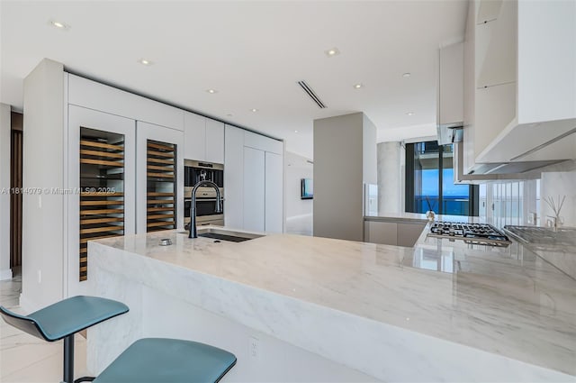 2200 N Ocean Blvd Unit S1801, Fort Lauderdale, FL 33305 - kitchen with a sink, modern cabinets, light stone counters, white cabinetry, and recessed lighting