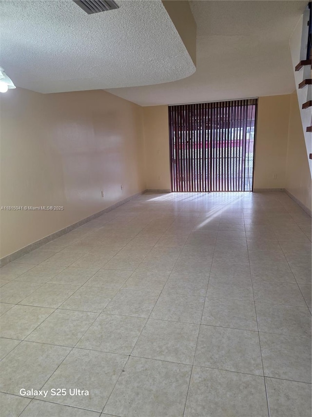 4102 W 10th Ln Unit 28, Hialeah, FL 33012 - tiled spare room featuring a textured ceiling and baseboards