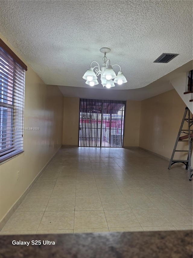 4102 W 10th Ln Unit 28, Hialeah, FL 33012 - tiled empty room with a chandelier, a textured ceiling, and baseboards