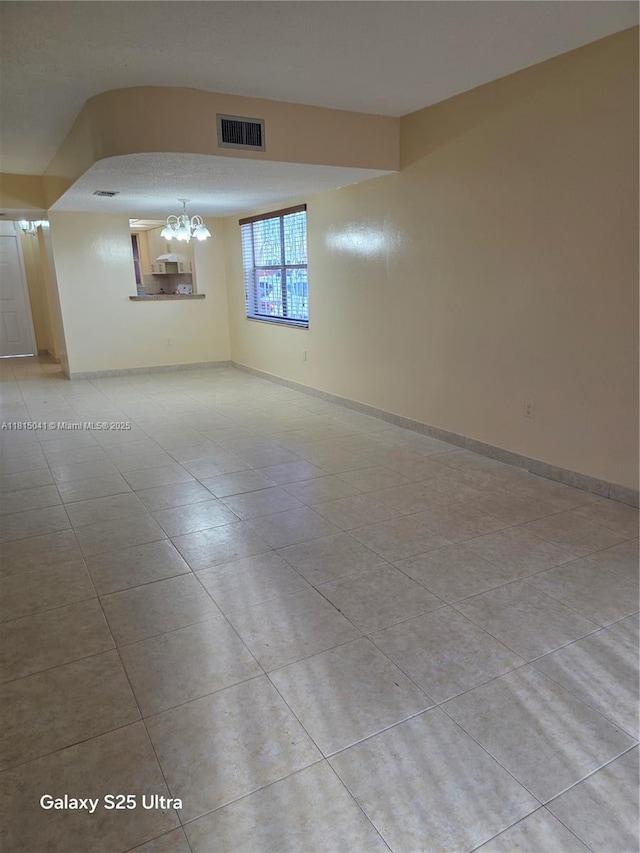 4102 W 10th Ln Unit 28, Hialeah, FL 33012 - empty room featuring a chandelier, light tile patterned floors, and baseboards