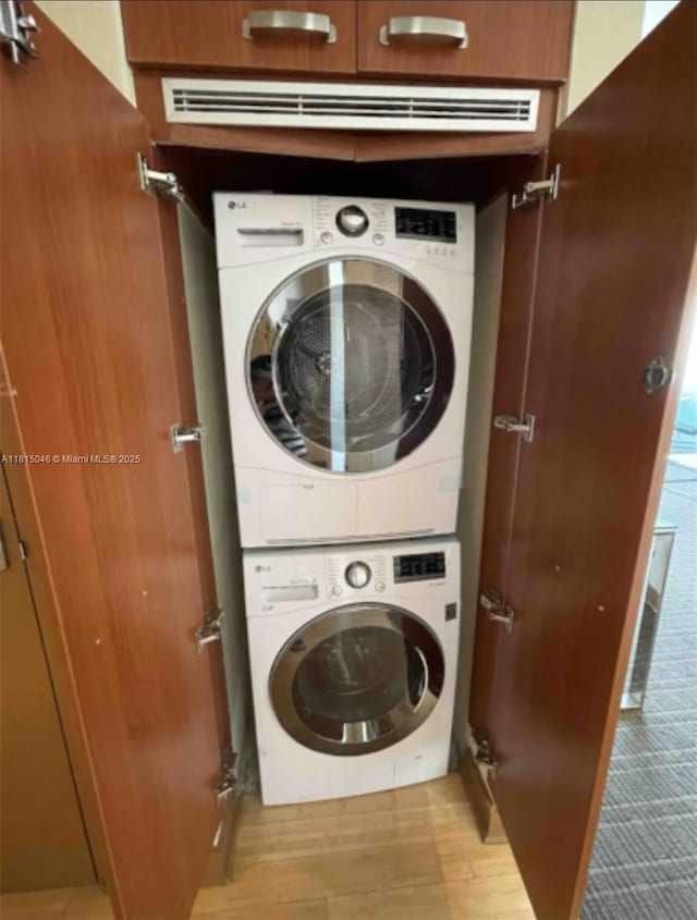 1395 Brickell Ave Unit 2814, Miami, FL 33131 - laundry room featuring stacked washer / dryer and wood finished floors