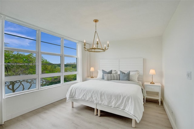 3150 N Course Ln Unit 405, Pompano Beach, FL 33069 - bedroom featuring a chandelier, light wood-style flooring, and baseboards