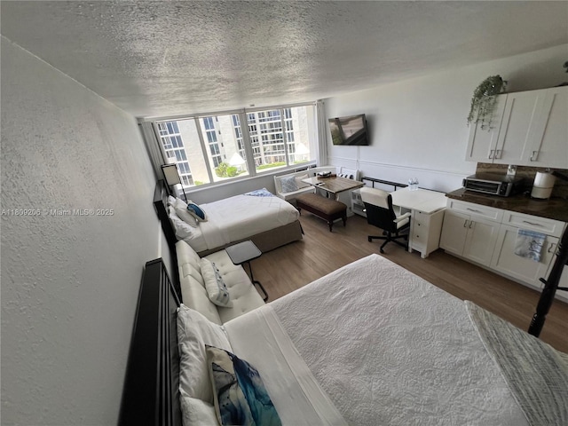 19201 Collins Ave Unit 427, Sunny Isles Beach, FL 33160 - bedroom featuring a textured ceiling, wood finished floors, and a textured wall