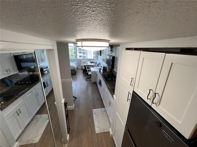 19201 Collins Ave Unit 427, Sunny Isles Beach, FL 33160 - kitchen featuring dark wood finished floors, white cabinets, and a textured ceiling