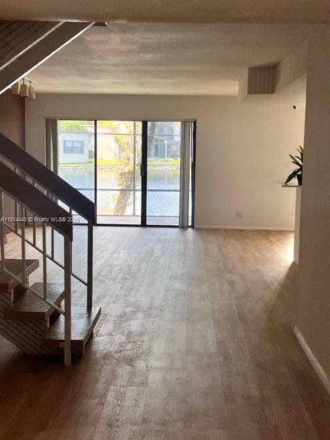 958 Mockingbird Ln Unit 511, Plantation, FL 33324 - hallway featuring stairs, wood finished floors, and baseboards