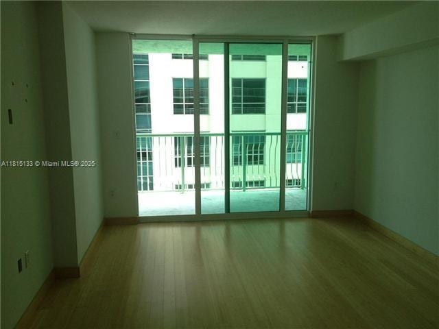 1200 Brickell Bay Dr Unit 3316, Miami, FL 33131 - doorway with healthy amount of natural light, wood finished floors, expansive windows, and baseboards