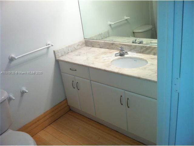 1200 Brickell Bay Dr Unit 3316, Miami, FL 33131 - half bath featuring toilet, vanity, and wood finished floors