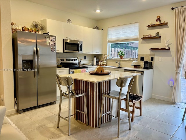 12254 NW 24th Pl, Miami, FL 33167 - kitchen with appliances with stainless steel finishes, a breakfast bar, tasteful backsplash, white cabinets, and a sink