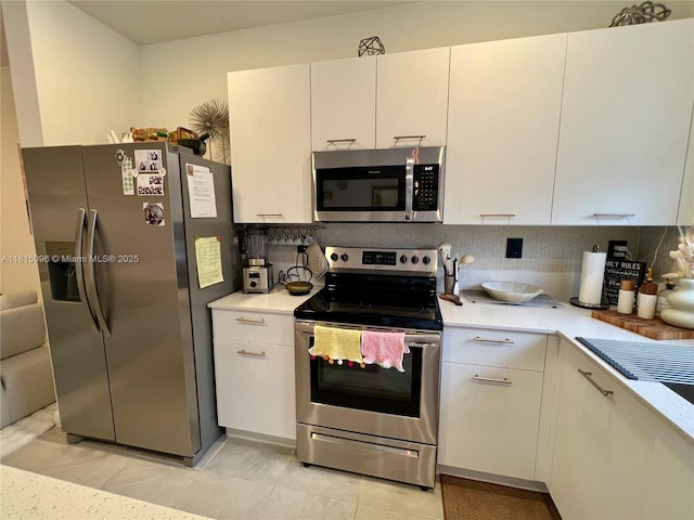 12254 NW 24th Pl, Miami, FL 33167 - kitchen with appliances with stainless steel finishes, light countertops, decorative backsplash, light tile patterned flooring, and white cabinets