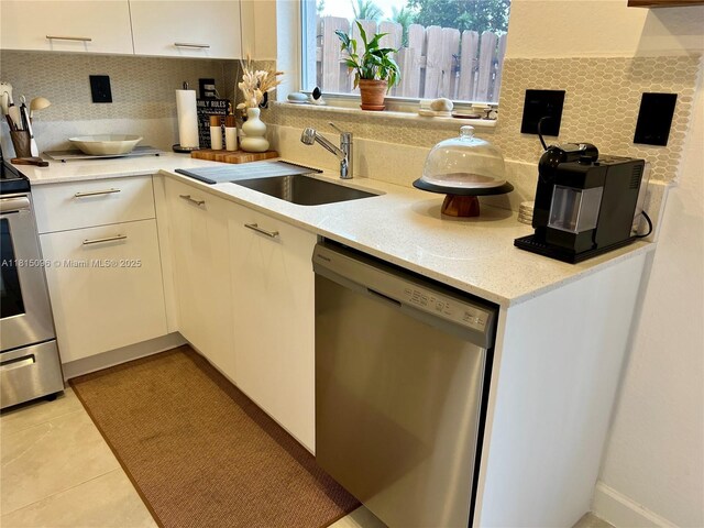 12254 NW 24th Pl, Miami, FL 33167 - kitchen featuring appliances with stainless steel finishes, tasteful backsplash, white cabinetry, and light tile patterned floors