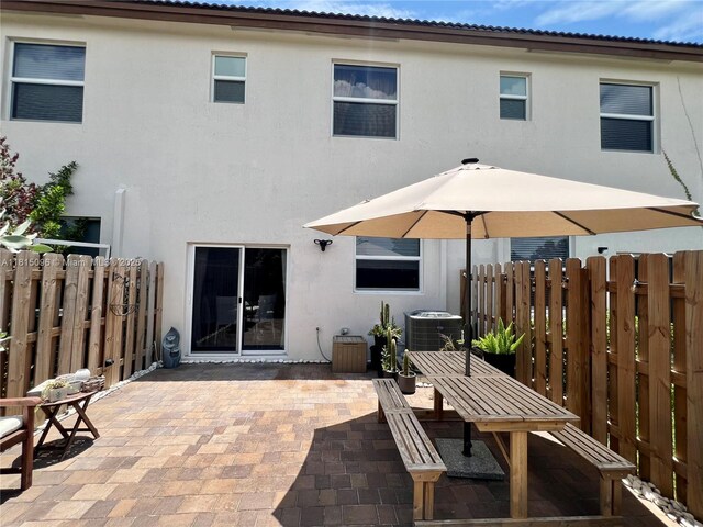 12254 NW 24th Pl, Miami, FL 33167 - rear view of house featuring stucco siding, a patio area, cooling unit, and outdoor dining area