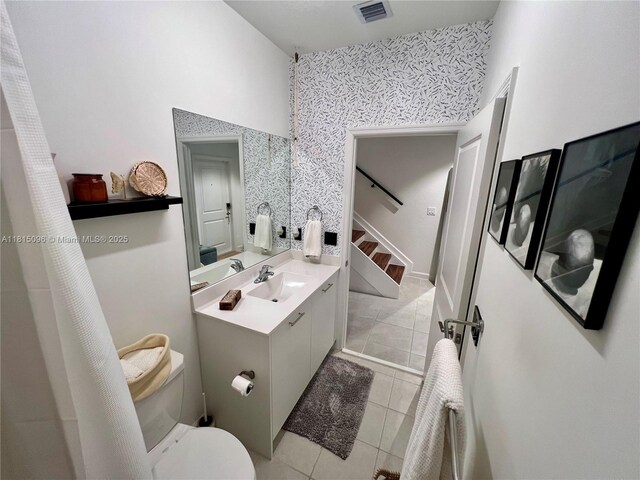 12254 NW 24th Pl, Miami, FL 33167 - full bathroom featuring tile patterned flooring, vanity, toilet, a high ceiling, and wallpapered walls