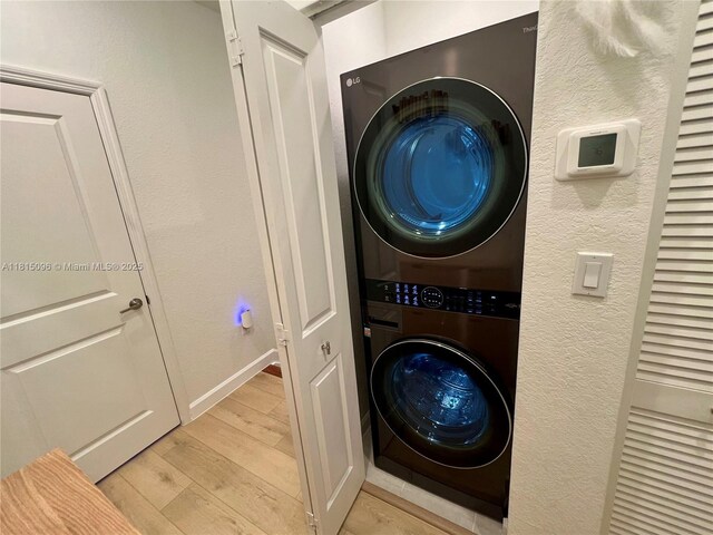 12254 NW 24th Pl, Miami, FL 33167 - laundry area featuring stacked washer / dryer, light wood-style flooring, and baseboards