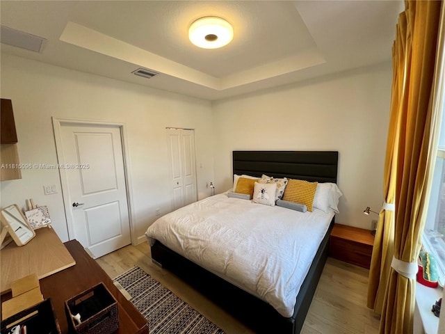 12254 NW 24th Pl, Miami, FL 33167 - bedroom with light wood-style flooring and a tray ceiling