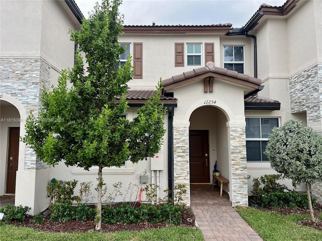 12254 NW 24th Pl, Miami, FL 33167 - view of front of home with stucco siding, stone siding, and a tile roof