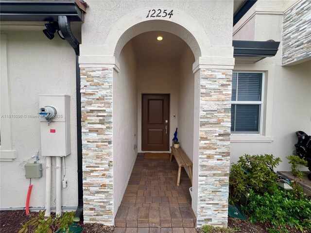 12254 NW 24th Pl, Miami, FL 33167 - doorway to property with stone siding and stucco siding