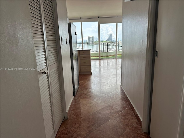 555 NE 15th St Unit 515, Miami, FL 33132 - hall with a wall of windows, baseboards, a water view, and a textured wall