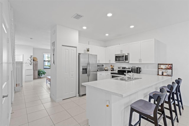 12945 SW 234th St, Homestead, FL 33032 - kitchen with stainless steel appliances, a sink, a peninsula, a kitchen bar, and light countertops