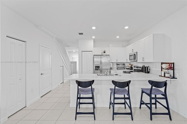 12945 SW 234th St, Homestead, FL 33032 - kitchen featuring stainless steel appliances, a peninsula, a kitchen bar, light countertops, and recessed lighting