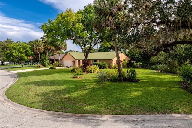 4559 Springview Cir, La Belle, FL 33935 - view of front of house featuring an attached garage, a front yard, and driveway