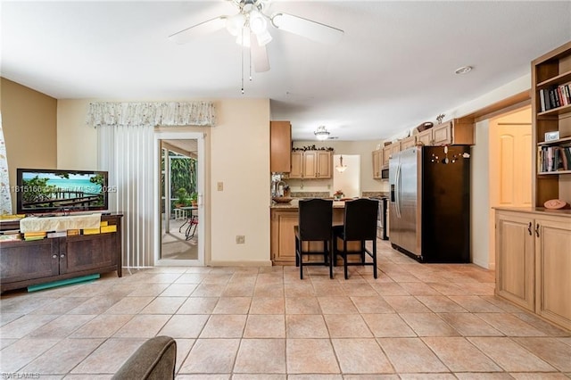 4559 Springview Cir, La Belle, FL 33935 - kitchen featuring stainless steel appliances, a ceiling fan, a peninsula, a kitchen bar, and light tile patterned flooring