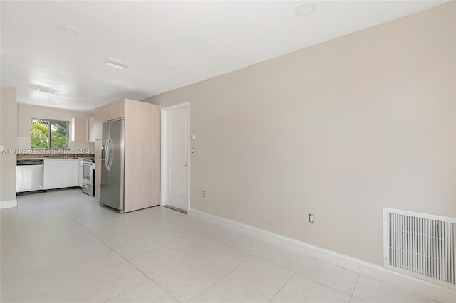 811 NW 3rd Ave, Fort Lauderdale, FL 33311 - kitchen featuring stainless steel appliances, light brown cabinets, light countertops, and light tile patterned floors