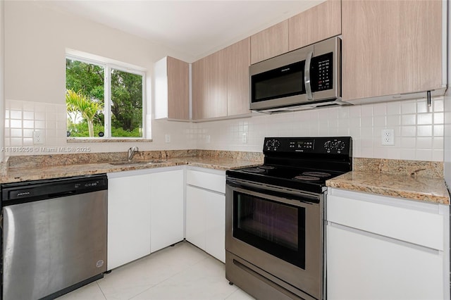 811 NW 3rd Ave, Fort Lauderdale, FL 33311 - kitchen with appliances with stainless steel finishes, tasteful backsplash, light stone counters, light tile patterned floors, and modern cabinets