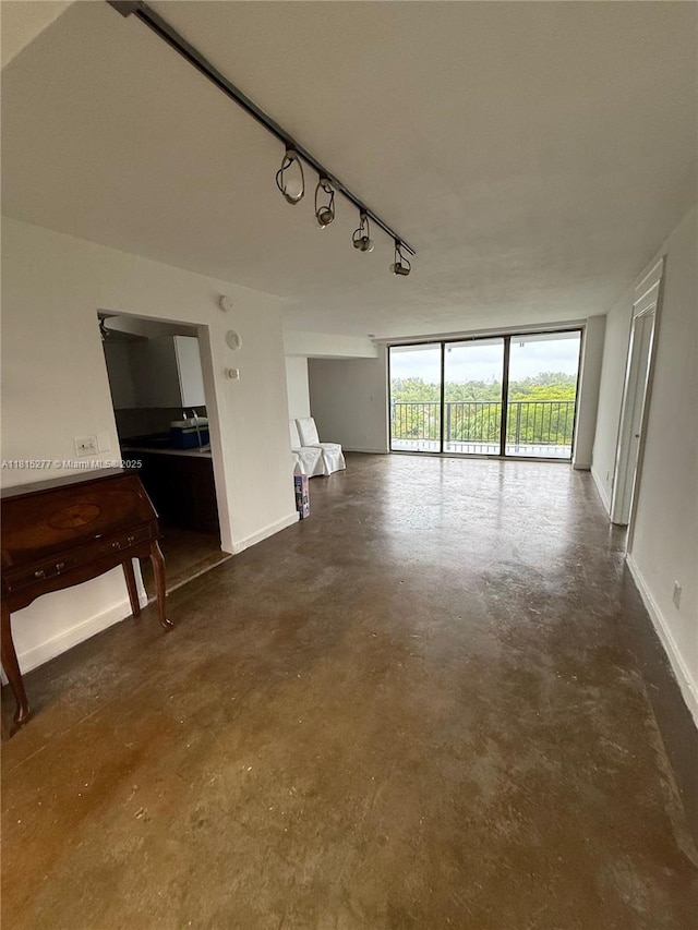 5701 Biscayne Blvd Unit 701, Miami, FL 33137 - unfurnished living room with finished concrete floors, rail lighting, and baseboards
